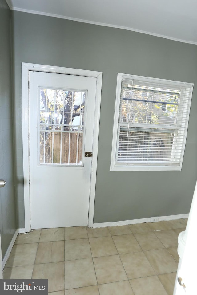 doorway to outside featuring light tile patterned floors and ornamental molding