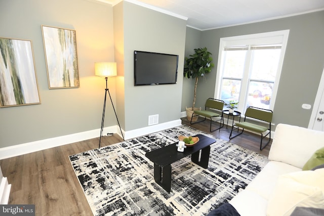 living room with hardwood / wood-style floors and crown molding