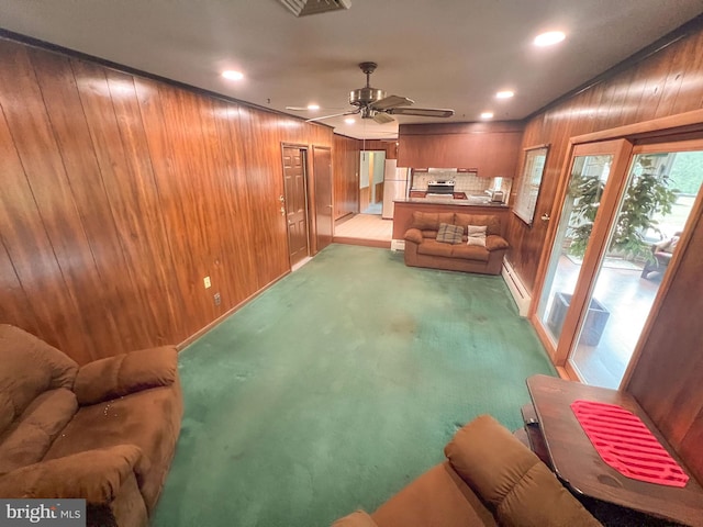 living room with light carpet, ceiling fan, and wooden walls