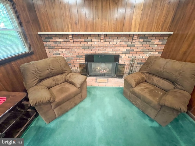 living room with carpet flooring, wooden walls, and a fireplace