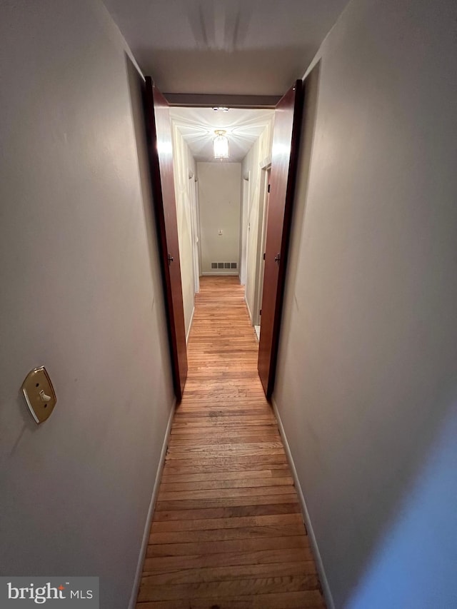 hallway with light hardwood / wood-style floors