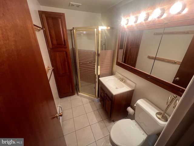 bathroom featuring tile patterned flooring, vanity, toilet, and a shower with shower door