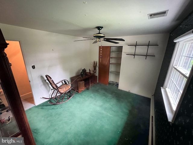 interior space with carpet and ceiling fan