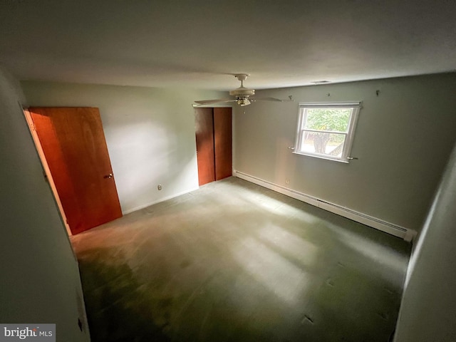 carpeted spare room with a baseboard heating unit