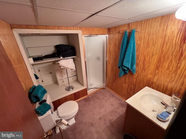 bathroom with a paneled ceiling, wood walls, and a shower with door