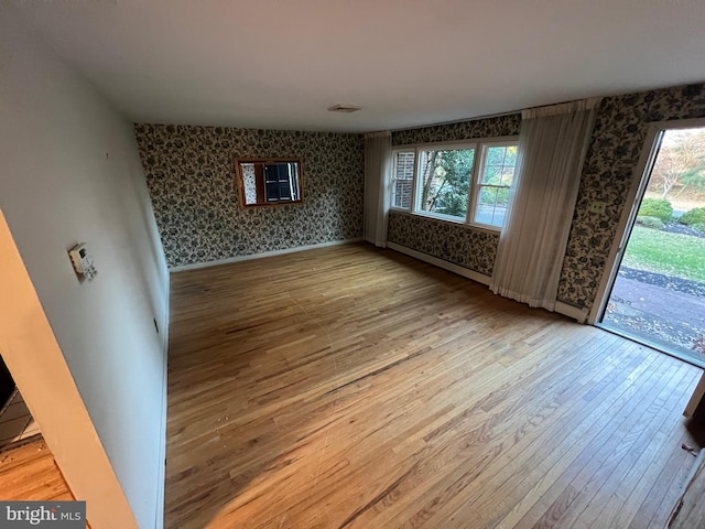 empty room with baseboard heating and hardwood / wood-style floors