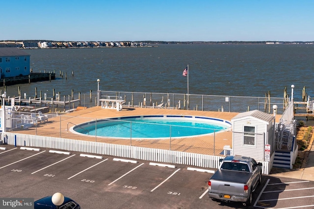 view of swimming pool featuring a patio and a water view