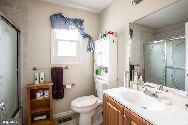 bathroom with vanity, toilet, and a shower with shower door