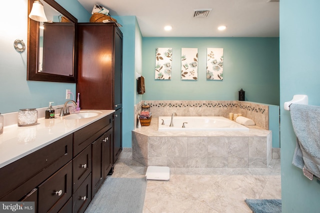 bathroom with tiled bath and vanity