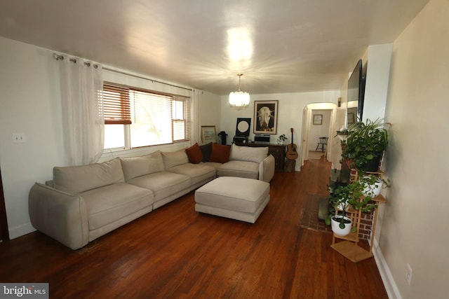 living room with dark hardwood / wood-style floors and an inviting chandelier