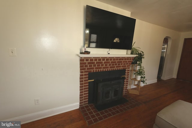 living room featuring dark hardwood / wood-style flooring and a brick fireplace