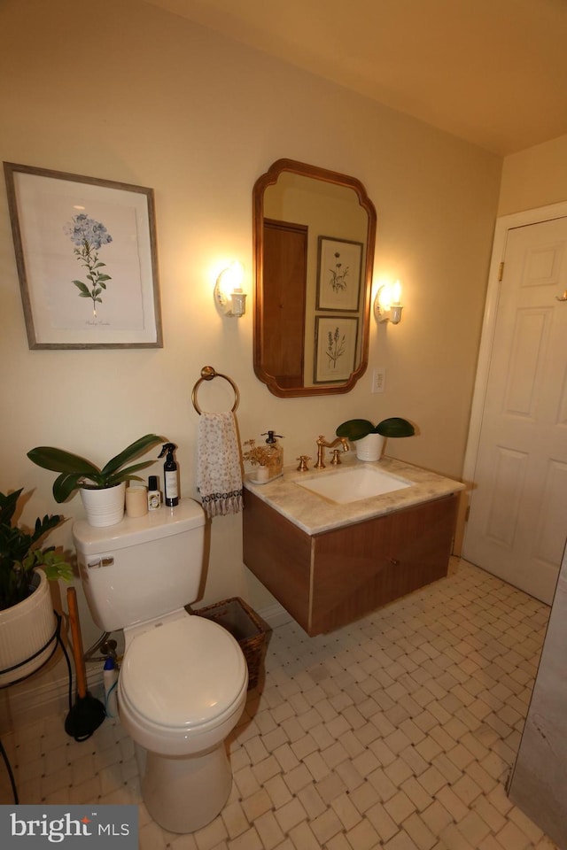 bathroom featuring tile patterned flooring, vanity, and toilet