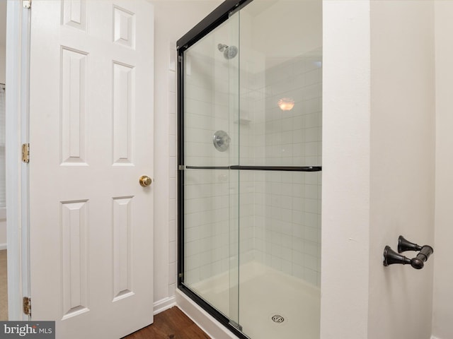 bathroom with wood-type flooring and walk in shower