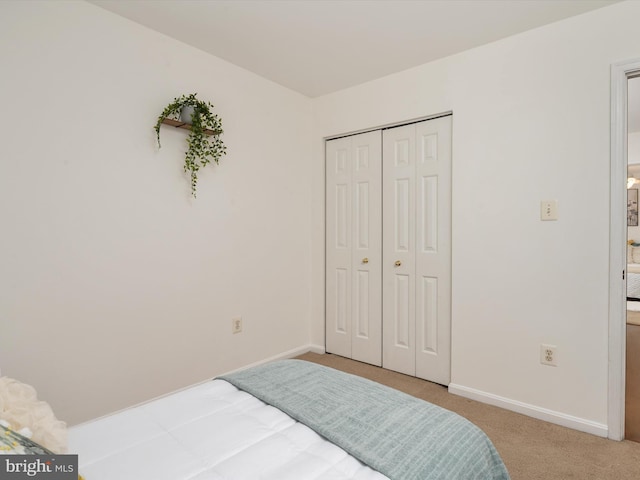 bedroom featuring a closet and light colored carpet