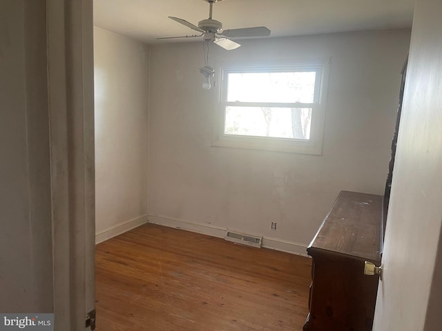 spare room with ceiling fan and wood-type flooring