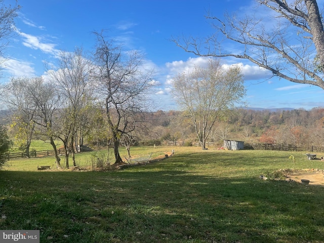 view of yard featuring a rural view and a shed