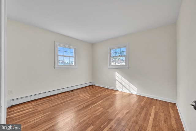 spare room with light hardwood / wood-style flooring and a baseboard heating unit