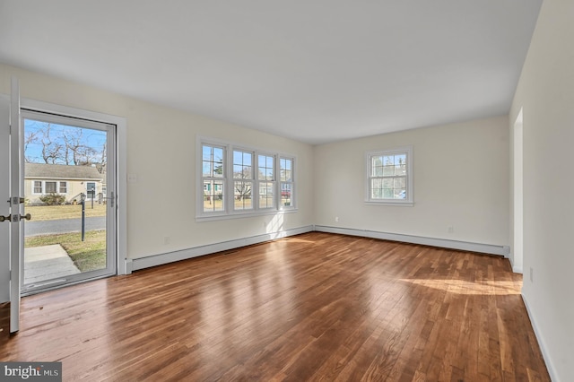 empty room with hardwood / wood-style flooring and baseboard heating