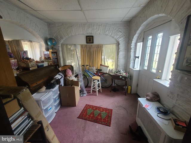 misc room with a paneled ceiling and carpet