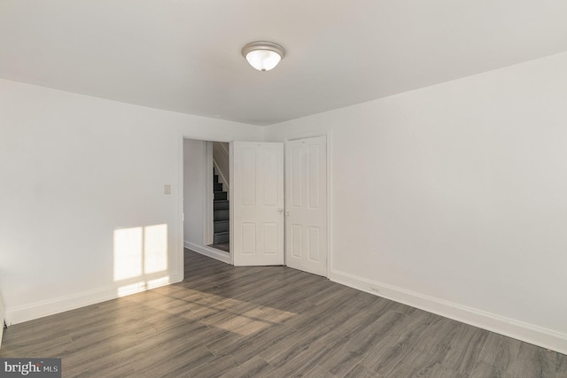 unfurnished room featuring dark wood-type flooring