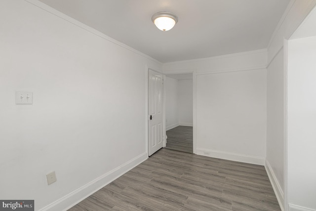 spare room with wood-type flooring and ornamental molding