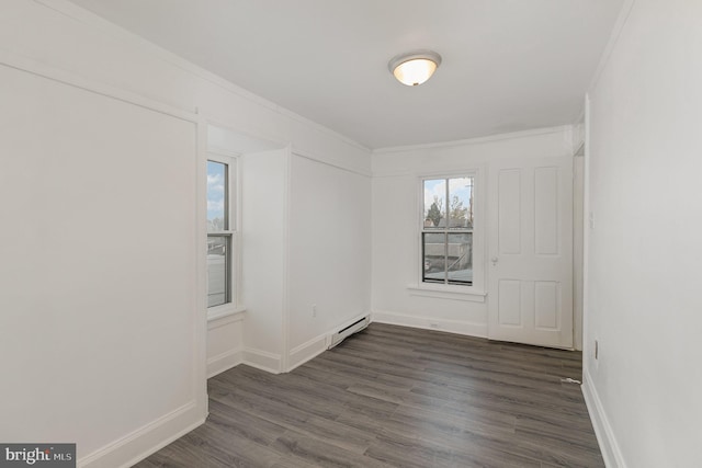 unfurnished room with dark hardwood / wood-style flooring, baseboard heating, and ornamental molding