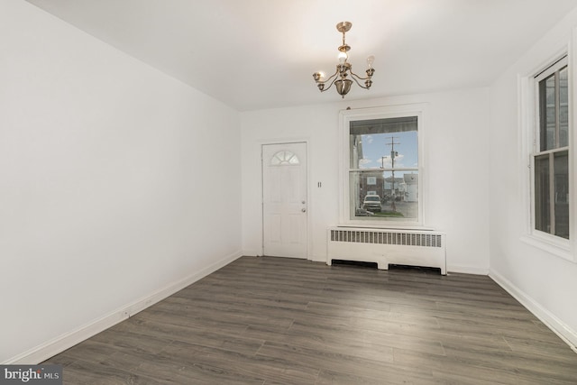 interior space with a notable chandelier, dark hardwood / wood-style floors, and radiator heating unit