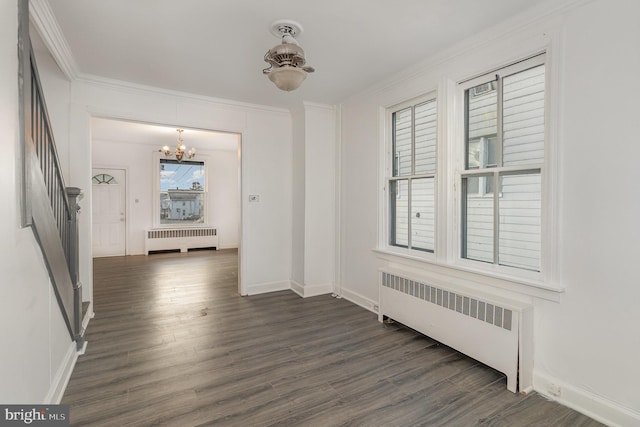 corridor with ornamental molding, radiator heating unit, dark wood-type flooring, and a notable chandelier