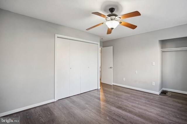 unfurnished bedroom featuring hardwood / wood-style flooring, ceiling fan, and multiple closets