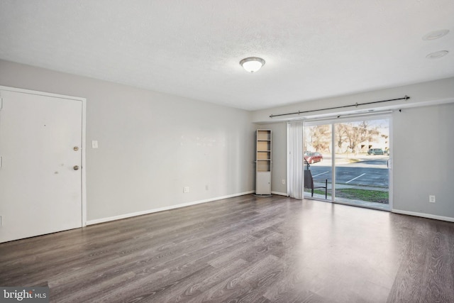 empty room with a textured ceiling and hardwood / wood-style flooring