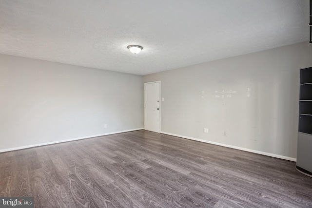 unfurnished room featuring dark hardwood / wood-style floors and a textured ceiling