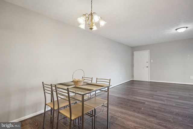 dining room featuring dark hardwood / wood-style flooring, a textured ceiling, and a notable chandelier