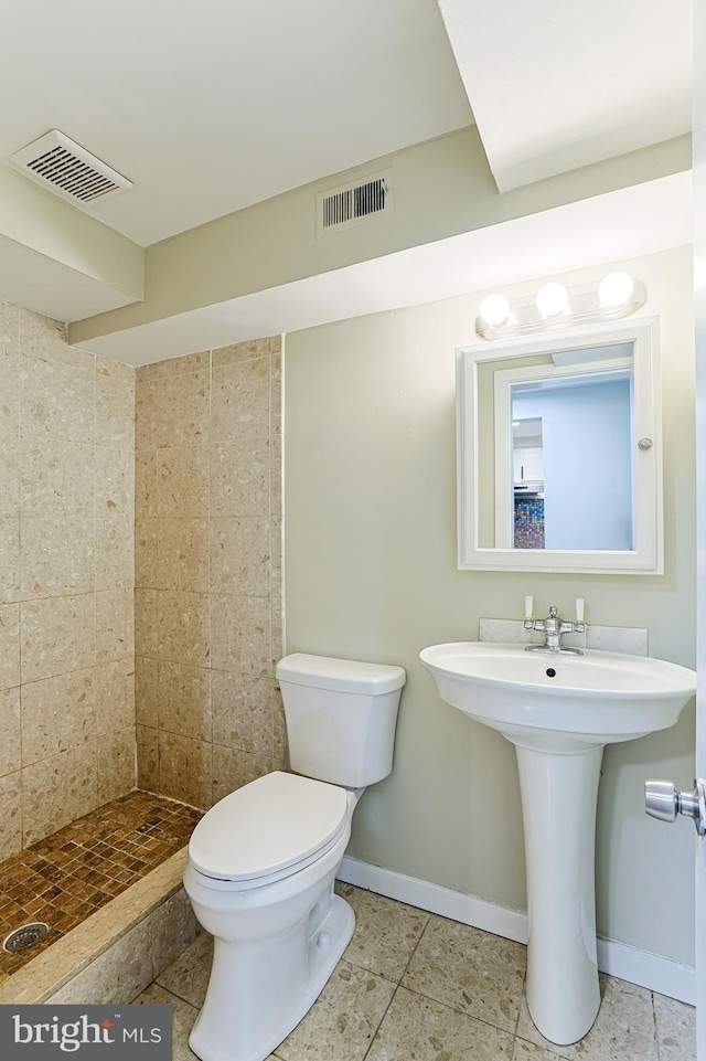 bathroom with tiled shower, tile patterned floors, and toilet