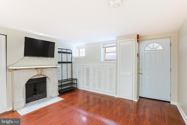 unfurnished living room featuring hardwood / wood-style flooring and a premium fireplace