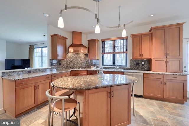 kitchen featuring premium range hood, a kitchen island, appliances with stainless steel finishes, pendant lighting, and sink