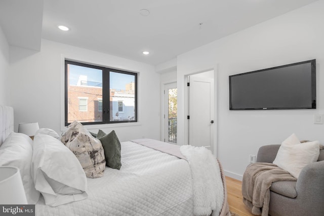 bedroom with access to outside, light hardwood / wood-style floors, and multiple windows