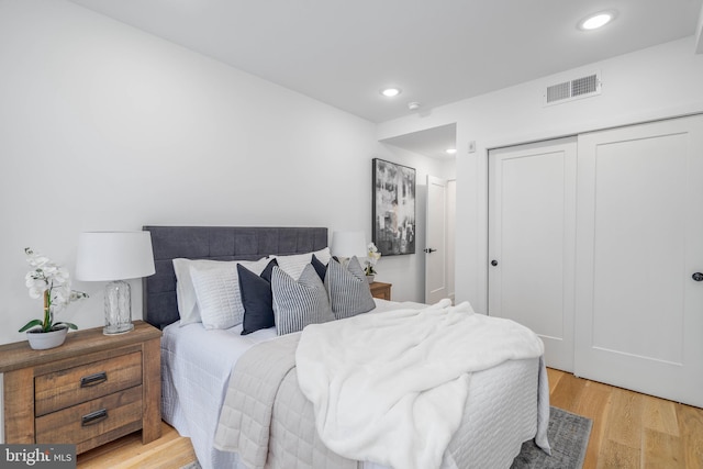 bedroom with light hardwood / wood-style flooring and a closet