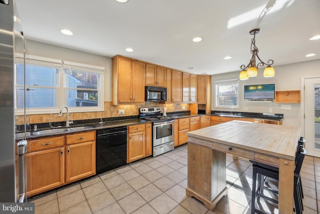 kitchen featuring backsplash, black appliances, sink, decorative light fixtures, and light tile patterned flooring