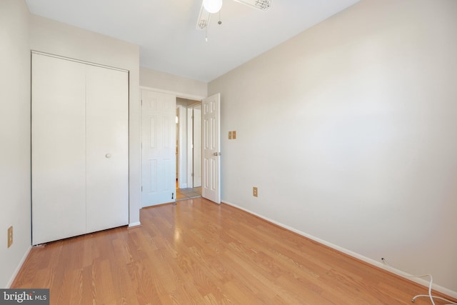 unfurnished bedroom with light wood-type flooring, a closet, and ceiling fan