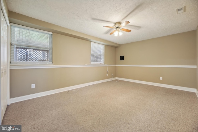 spare room with plenty of natural light, carpet, and a textured ceiling