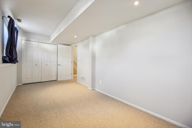 unfurnished bedroom with light carpet and a closet