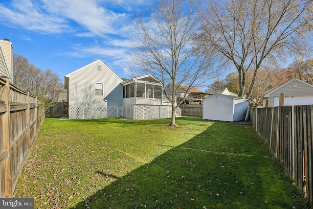 view of yard featuring a sunroom and a storage unit