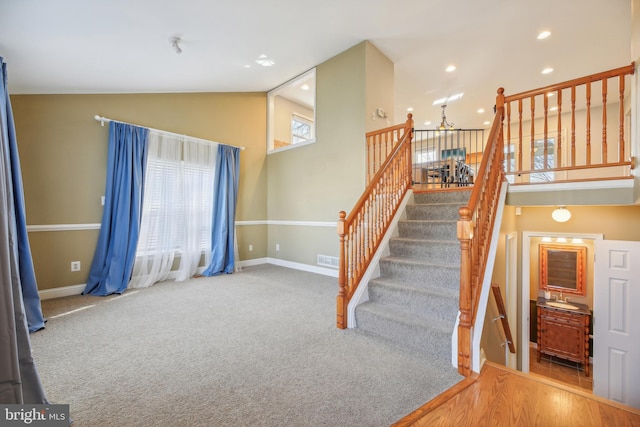 stairway featuring hardwood / wood-style flooring and vaulted ceiling