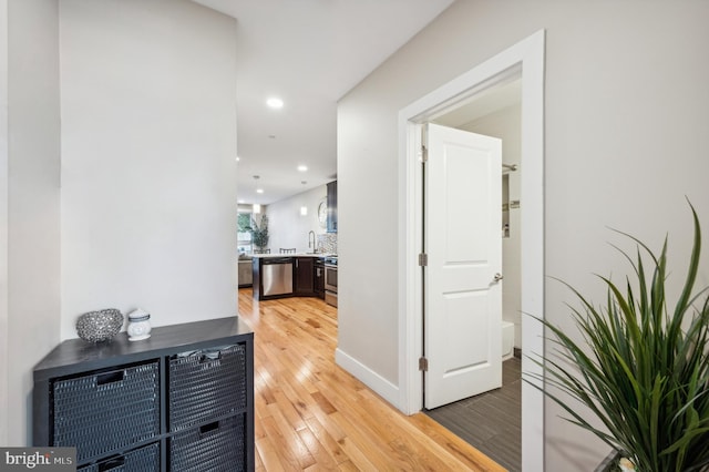 hallway featuring hardwood / wood-style flooring and sink