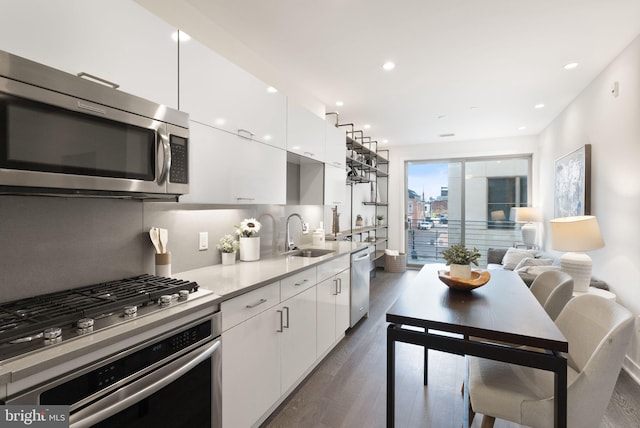 kitchen featuring sink, dark hardwood / wood-style floors, decorative backsplash, white cabinetry, and stainless steel appliances