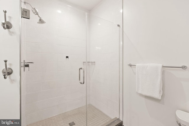 bathroom with a shower with door and toilet