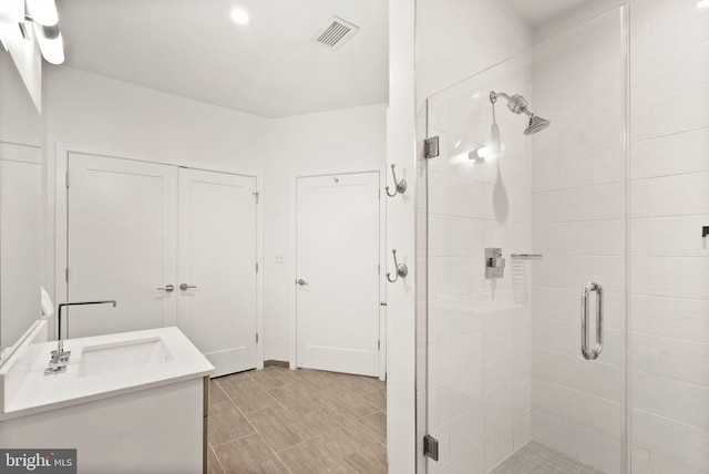 bathroom with vanity and a shower with door