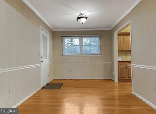 unfurnished dining area with light wood-type flooring and crown molding