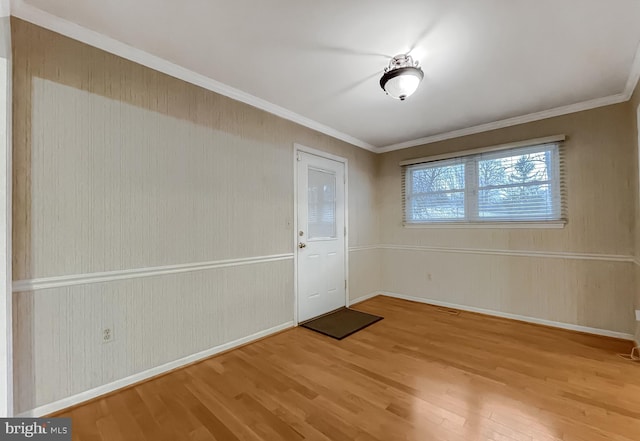 foyer with crown molding and hardwood / wood-style floors