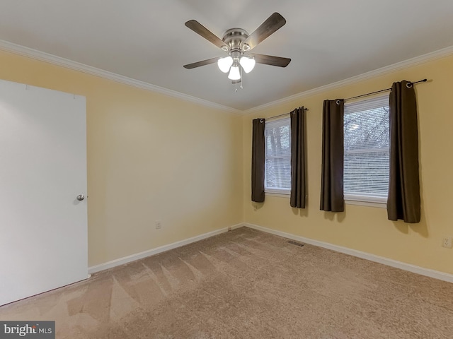 carpeted empty room featuring ceiling fan and crown molding